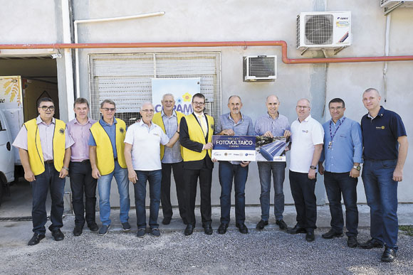 Várias pessoas em pé segurando um cartaz do "Projeto fotovoltaico"