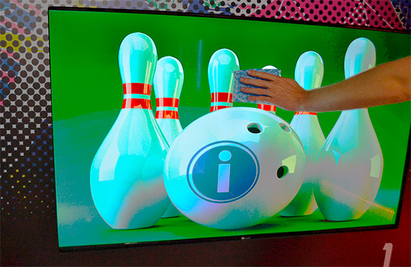Tela de com uma bola de boliche e pino atrás dela, com uma mão na frente da tela.