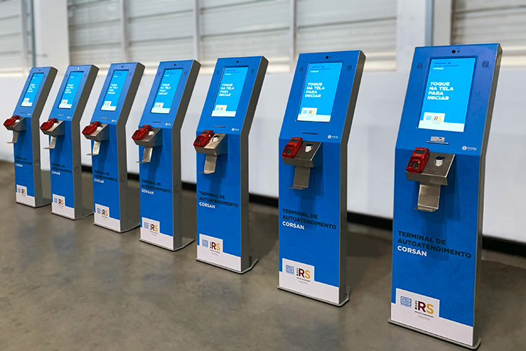 Fileira de terminais de autoatendimento Corsan enfileirados um ao lado do outro.