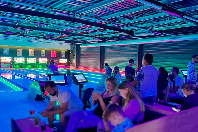 Pista de boliche com varias pessoas jogando