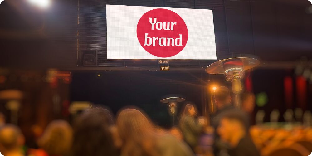 Logo de marca evento em um outdoor noturno.