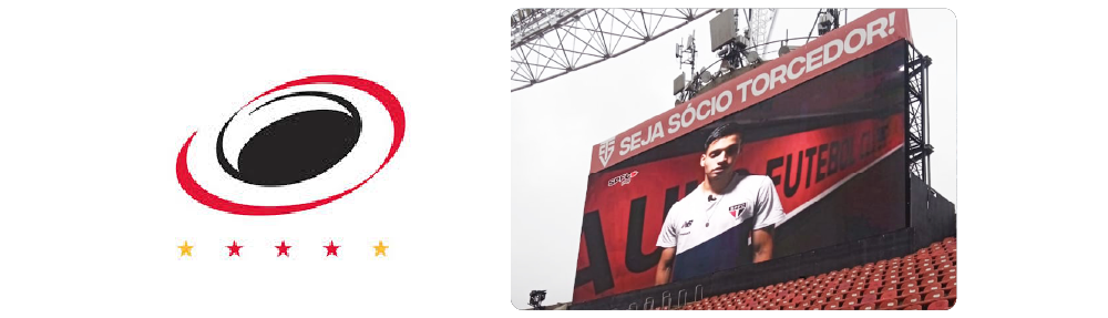 Logotipo circular vermelho e preto com quatro estrelas abaixo, ao lado de uma imagem gigante de um jogador de futebol em um placar de um estádio.