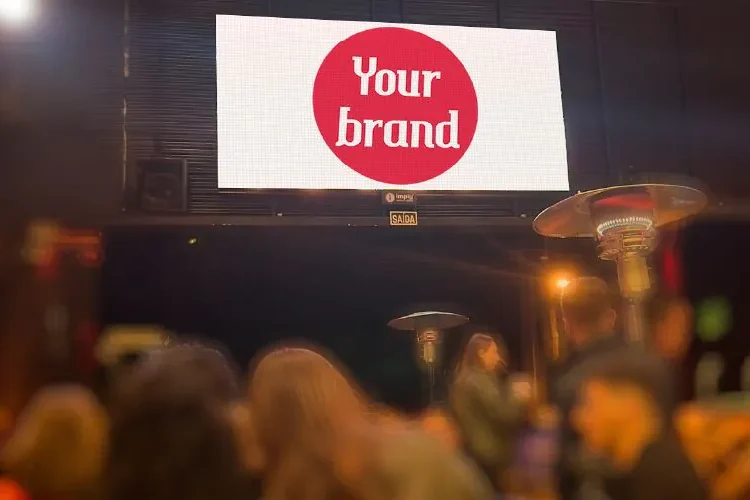 Painel publicitário iluminado em cidade à noite