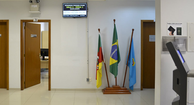 Corredor com um painel de senhas para atendimento